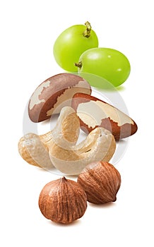 Cashew, hazelnut, brazil nuts and green grapes isolated on white background. Nut mix. Vertical layout