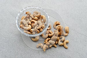 Cashew Nut, in Indonesia known as Kacang Mete. Served in a small bowl on grey background. photo