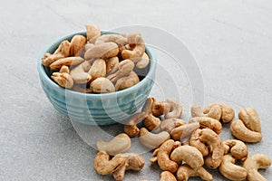 Cashew Nut, in Indonesia known as Kacang Mete. Served in a small bowl on grey background. photo
