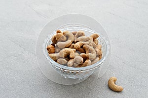 Cashew Nut, in Indonesia known as Kacang Mete. Served in a small bowl on grey background photo