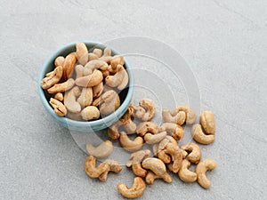 Cashew Nut, in Indonesia known as Kacang Mete. Served in a small bowl on grey background.