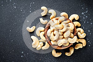 Cashew nuts in bowl at black background.