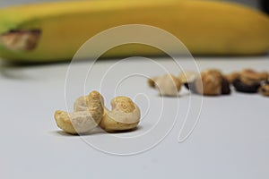 Cashew nuts close up and banana with other nuts background