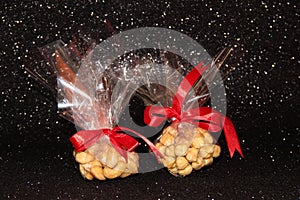 Cashew nuts and hazelnuts in a package on a black shiny background. Hazelnut