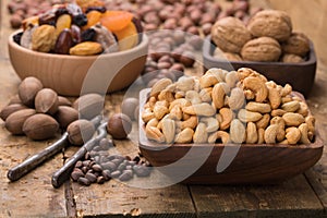 Cashew nuts peeled roasted in wooden bowl on table, grunge style