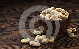 Cashew nuts in wooden bowl on black background