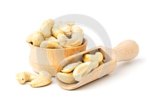 Cashew in wooden plate and spoon on a white background, close-up. photo