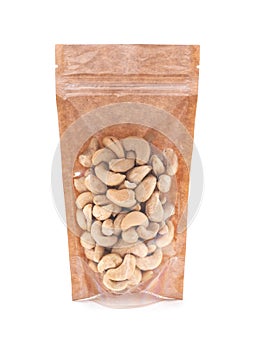 Cashews in a brown paper bag. Doy-pack with a plastic window for bulk products. Close-up. White background. Isolated