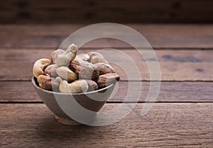 Cashews nuts with shells,homemade roasted process on wooden background