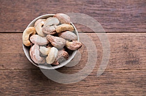 Cashews nuts with shells,homemade roasted process on wooden background