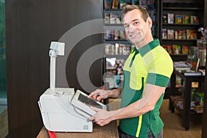 Cashier at cash register in shop or store