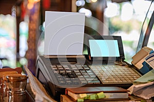 Cashier counter with digital screen and white label on wooden table