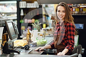 Cashier lady on workspace in supermarket shop