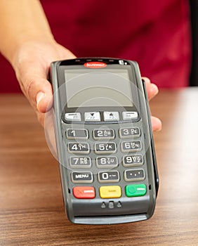 Cashier offering POS terminal for payment with credit card