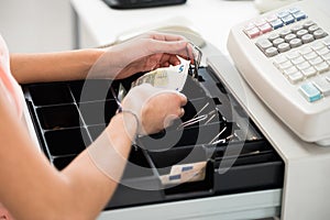 Cashier Searching For Change In Cash Register Drawer