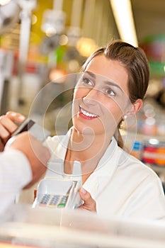 Cashier in supermarket taking credit card