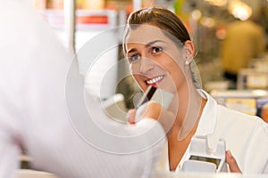 Cashier in supermarket taking credit card