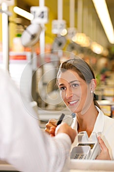 Cashier in supermarket taking credit card