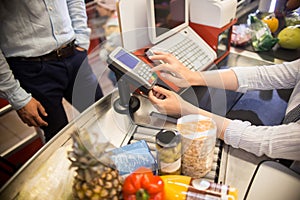 Cashier Using Payment Terminal in Supermarket photo