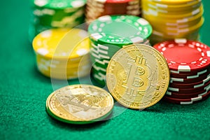 Casino chips and bitcoin cryptocurrency on green table