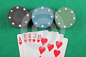 Casino chips and cards with a winning combination of royal flush on the table