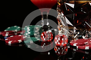 Casino chips, dice and alcohol drinks on dark background, closeup