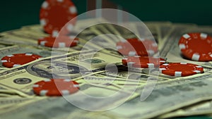 Casino chips falling on dollar bills, big winnings, jack-pot, slow-motion