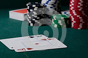 Casino chips and pair of aces on the green table. Poker game