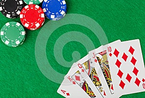 Casino chips and playing cards on green table