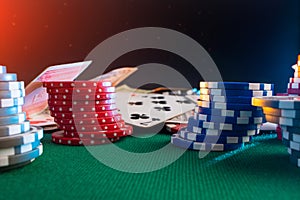 Casino chips on a poker table against the background of cards, money with creative light