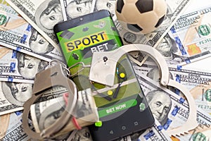 Casino chips, soccer ball and dice standing on smartphone with football pitch.