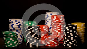 Casino chips stacks isolated on black, risky all-in bet, underground casino