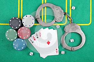 Casino chips winning combination of cards four aces next to police handcuffs