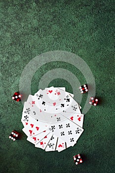 Casino concept, playing cards laid out in a circle and dice on a green table top view