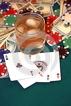 Close up of four of aces, chips and cash on gambling table. Poker concept.