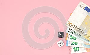 Casino, gambling and fortune concept - close up of black and white dice and euro money on pink background with copy space