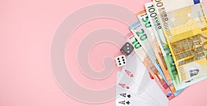 Casino, gambling and fortune concept. Game bones and cards and euro money on pink background with copy space
