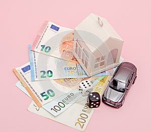 Casino, gambling and fortune concept. Model house and car, games dice and euro money on pink background with copy space
