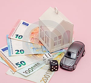 Casino, gambling and fortune concept. Model house and car, games dice and euro money on pink background with copy space