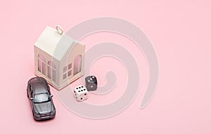 Casino, gambling and fortune concept. Model house and car, games dice on pink background with copy space