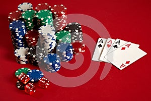 Casino gambling poker equipment and entertainment concept - close up of playing cards and chips at red background. Four