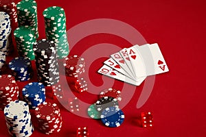 Casino gambling poker equipment and entertainment concept - close up of playing cards and chips at red background. Royal
