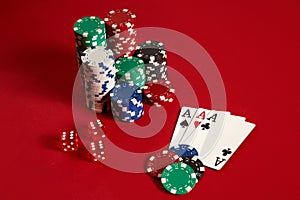 Casino gambling poker equipment and entertainment concept - close up of playing cards and chips at red background. Three