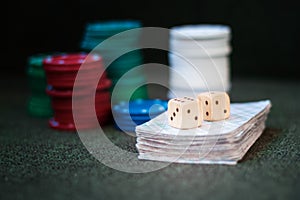 Casino poker chips stack with playing cards, dice on green felt background