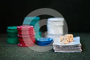 Casino poker chips stack with playing cards, dice on green felt background