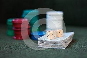 Casino poker chips stack with playing cards, dice on green felt background