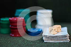 Casino poker chips stack with playing cards, dice on green felt background