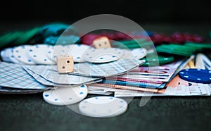 Casino poker chips stack with playing cards, dice and money on green felt background