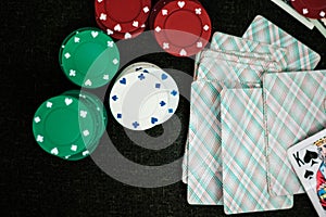 Casino poker chips stack with playing cards, dice and money on green felt background