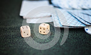 Casino poker chips stack with playing cards, dice and money on green felt background